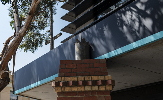 A brick sculpture of a chimney in a suburban street
