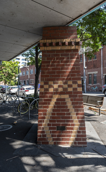 A brick sculpture of a chimney in a suburban street