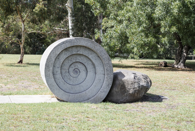 A concreate path leading to a concrete path sculpture giving the illusion the path as been rolled out. 