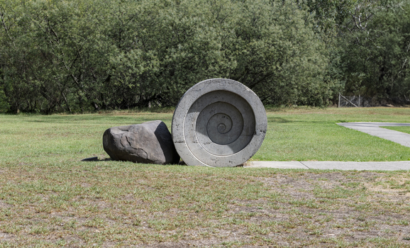 A concreate path leading to a concrete path sculpture giving the illusion the path as been rolled out. 