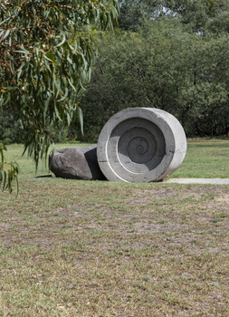A concreate path leading to a concrete path sculpture giving the illusion the path as been rolled out. 