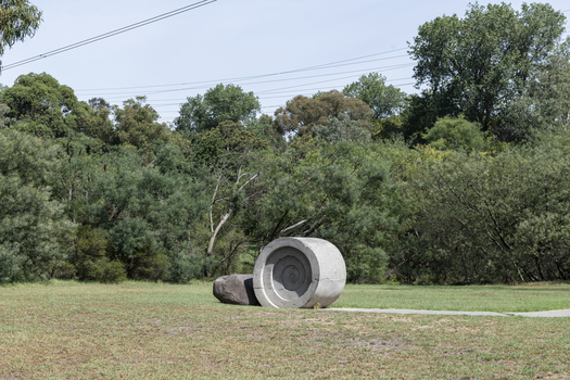A concreate path leading to a concrete path sculpture giving the illusion the path as been rolled out. 