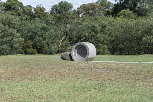 A concreate path leading to a concrete path sculpture giving the illusion the path as been rolled out. 