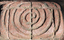 A detail of a swirling pattern on a brick sculpture.