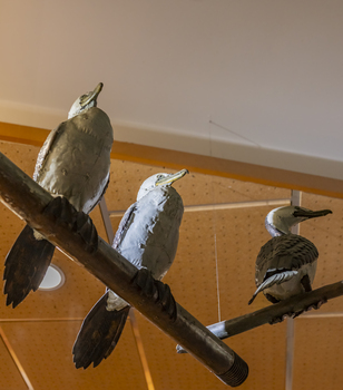 Three cormorant sculptures on a metal pole 