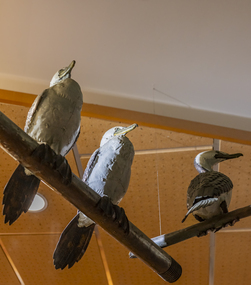 Three cormorant sculptures on a metal pole 