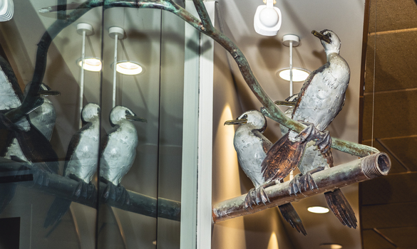 Three cormorant sculptures on a metal pole 