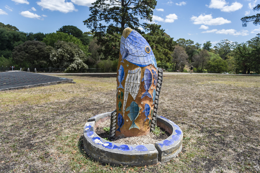 A large scale mosaic fish sculpture in a public park. 