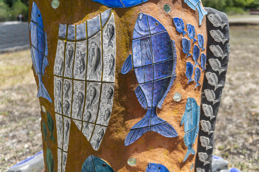 A large scale mosaic fish sculpture in a public park. 