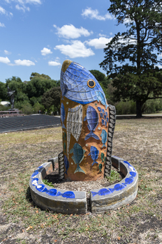 A large scale mosaic fish sculpture in a public park. 