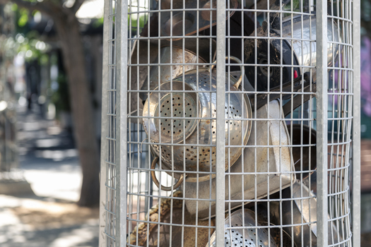 A series of large metal sculptures full of kitchenware (pots and pans etc)