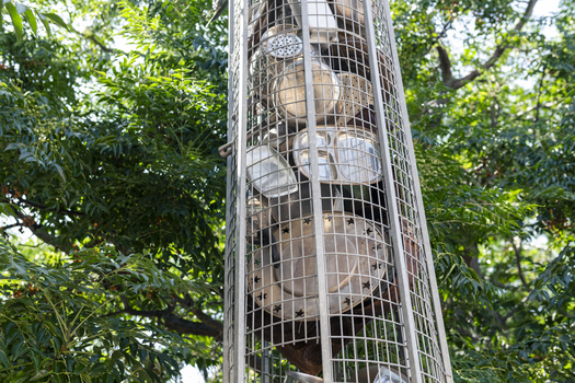 A series of large metal sculptures full of kitchenware (pots and pans etc)