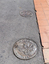 Lange bronze coins with Greek, Turkish and Italian iconography inlayed into the footpath. 