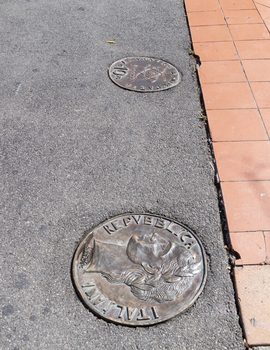 Lange bronze coins with Greek, Turkish and Italian iconography inlayed into the footpath. 