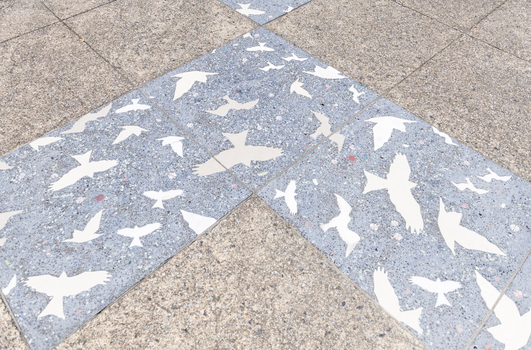 Pavers in a public space featuring a stylised flock of birds