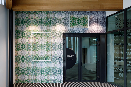 A geometric pattern print covering a wall with a vinyl wrap. There are 2 framed photos with the same pattern hung on the wall.  