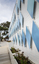The exterior of a small library building covered in approximately 100 blue metal diamond shaped motifs. 