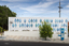 The exterior of a small library building covered in approximately 100 blue metal diamond shaped motifs. 