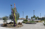 A large sculpture consisting of a series of striped and unstriped metal poles sticking out of the ground in a single cluster in a haphazard manner. there are approximately 15 of them and the sculpture is located on a street corner.