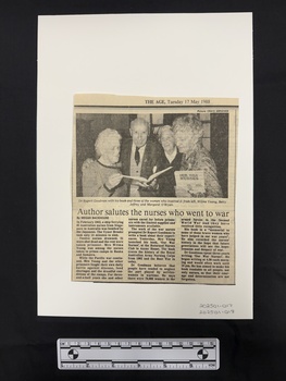 Newspaper clipping with publication title and date at the top and a photograph above three columns of text. Black and white photograph is of three older women and one older man holding copies of a book in their hands.