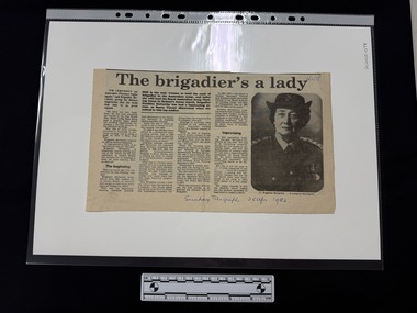 Newspaper clipping with a headline, four columns of text and a black and white portrait photograph of a woman in Australian Army Nurses uniform.