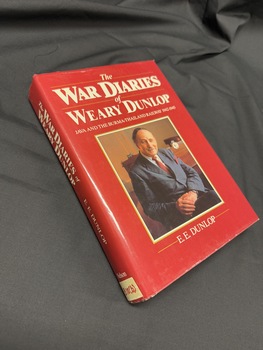 Book with a red dustjacket, had a photograph of a seated older man on cover and white text on cover and spine
