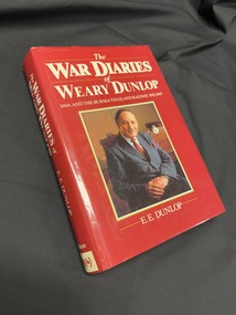 Book with a red dustjacket, had a photograph of a seated older man on cover and white text on cover and spine