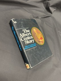 Book with a black dustjacket, has a painted portrait of an older man in uniform on cover and white and blue text on cover and spine