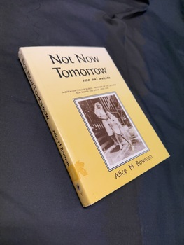 Paperback book with a yellow dustjacket that has a sepia photo on the cover and black writing on the cover and spine
