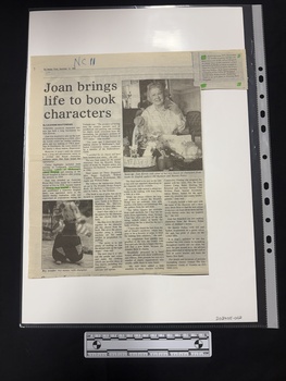Article with two black and white photographs, four columns of text and a small paragraph clipping attached with corrections printed after the article.  Parts are highlighted in green highlighter.