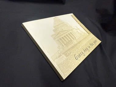 Paperback book with faded photograph of Melbourne Shrine of Remembrance as background of covers and spine with black text used