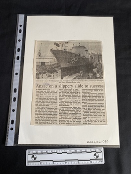 A newspaper clipping with a black and white photo of a ship at the top and three columns of text underneath. 
