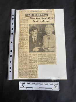 A newspaper clipping with four columns of text and a large black and white photo of a man and a woman