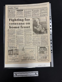 Full page clipping from a newspaper with main article and photo centre page with smaller article at the top and advertisements along the base of the page.