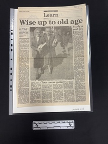 Full page, three articles using six columns of text surrounding a large black and white photograph of two older women holding books, standing outside