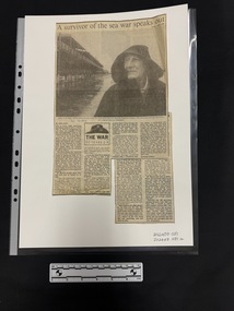 Two newspaper clippings of one article over different pages.  Article features six columns of text and a large black and white photograph of a man in a hooded raincoat standing near a pier.
