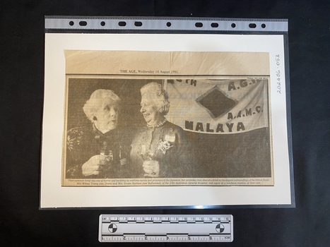 A newspaper clipping of a large black and white photo featuring two older women
