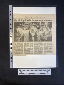 Newspaper clipping of a large black and white photo above four columns of text