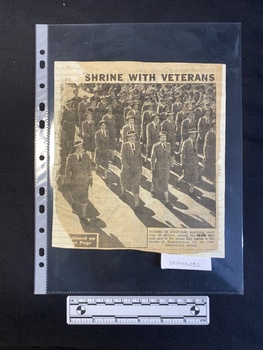 Torn newspaper clipping of part of a title, a large black and white photo and a caption