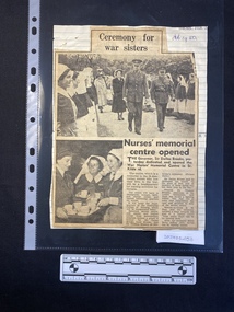A newspaper clipping of two black and white photos, one large, and a short story in two columns glued to a lined sheet of paper