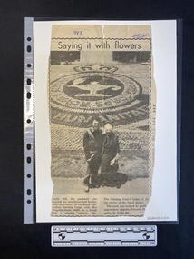 A newspaper clipping of a large black and white photo above two small columns of text