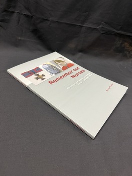 Grey and white paperback book with maroon and white writing on cover and spine. Cover also has images of a medal, uniform and portait of a woman in army nurses uniform.