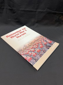 Tan and white paperback book with red, tan and white writing on cover and spine. Cover also has an image of women in army nursing uniforms standing in front of a field of tents