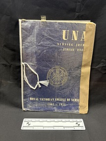 Plastic and sticky tape covered journal.  Cover of journal is dark blue with gold and white logo and writing