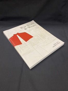 Paperback book with a white cover showing a basic outline of a nurse wearing a red cape. The title and author details are printed in black and in the background is a faded photo of a hospital building.