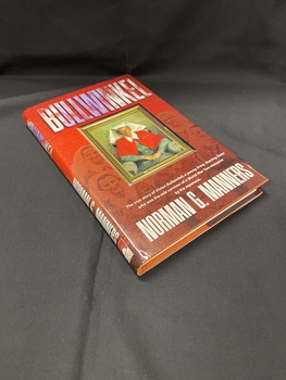 Bronze coloured hardcover book with gold writing on the cover depicting title and auther's name. The book is covered with a brown and red dust jacket with an image on the cover of a framed oil painting of Vivian Bullwinkel wearing her nurses' uniform.