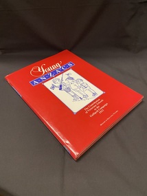 Hardcover book with maroon cover and 'Young ANZACS' printed across the front in gold. The book is covered with a red dust jacket with an image drawn inside a white rectangle on the front of three young children standing and waving flags.