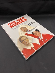 Hardcover book with a light grey cover. The title is printed across the top of the cover in red print, below this is the sub-title in black print. The author's name is in bold black print to the right, below the heading. The lower two thirds of the cover are filled with an image of three nurses in white uniforms and bright red capes.