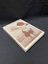 Cream coloured book with title printed in brown text across the top. Under the title is a large rectangle photo of a man and a woman riding two camels in Egypt in sepia tones. At the top of the image is a diamond with the subtitle printed inside, and inside that is a maroon rectangle with the author's name printed in white text. Next to this shape is an image of a gramaphone.