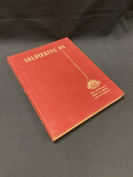 Maroon cloth bound hardcover book with title in cream print across the top, a straight line running vertical down the right side, below which is the Australian Commonwealth Military Forces emblem and the words 'the Australian Army at home and overseas'.
